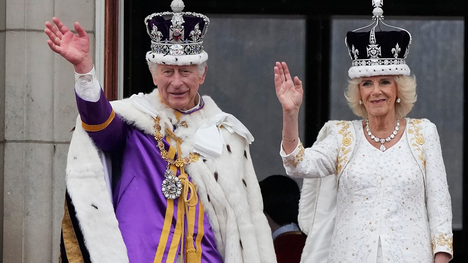 A crowned Camilla waves from the balcony of Buckingham Palace after her coronation with King Charles