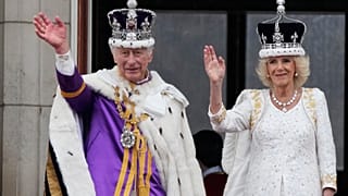 A crowned Camilla waves from the balcony of Buckingham Palace after her coronation with King Charles