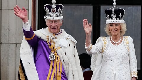A crowned Camilla waves from the balcony of Buckingham Palace after her coronation with King Charles