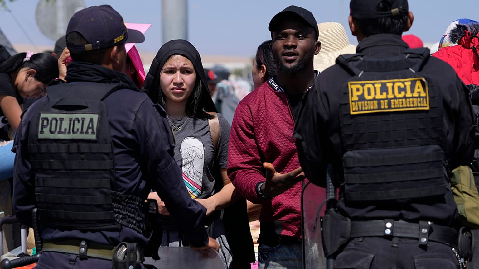 Venezuelan migrants speak with Peruvian police guarding the border with Chile in Tacna, Peru, Friday, April 28, 2023.