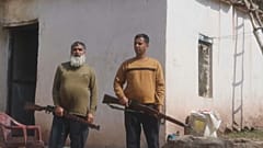 رجلان من سكان دنغاري يحملان بندقيتان 