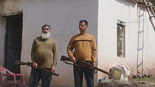 رجلان من سكان دنغاري يحملان بندقيتان 