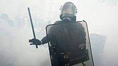 Ein Polizist steht inmitten von Tränengas-Schwaden während einer Demonstration am Maifeiertag in Paris