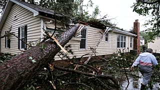 Eine Frau steht vor ihrem vom Sturm zerstörten Haus in Virginia Beach, USA