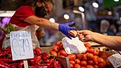 زبون يدفع مقابل الخضار في سوق مارافيلاس في مدريد. 2022/05/12