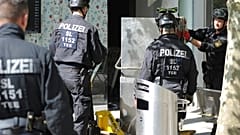 Police officers secure evidence during a raid in Saarlouis, Germany