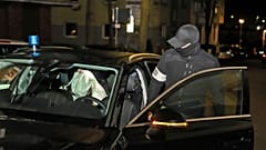 Полицейский садится в машину с арестованным во время рейда в среду, 3 мая 2023 года, в Хагене, Германия.