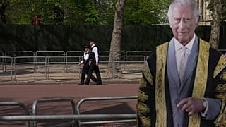 Police officers patrol besides a life-size cardboard of Britain's King Charles III in London