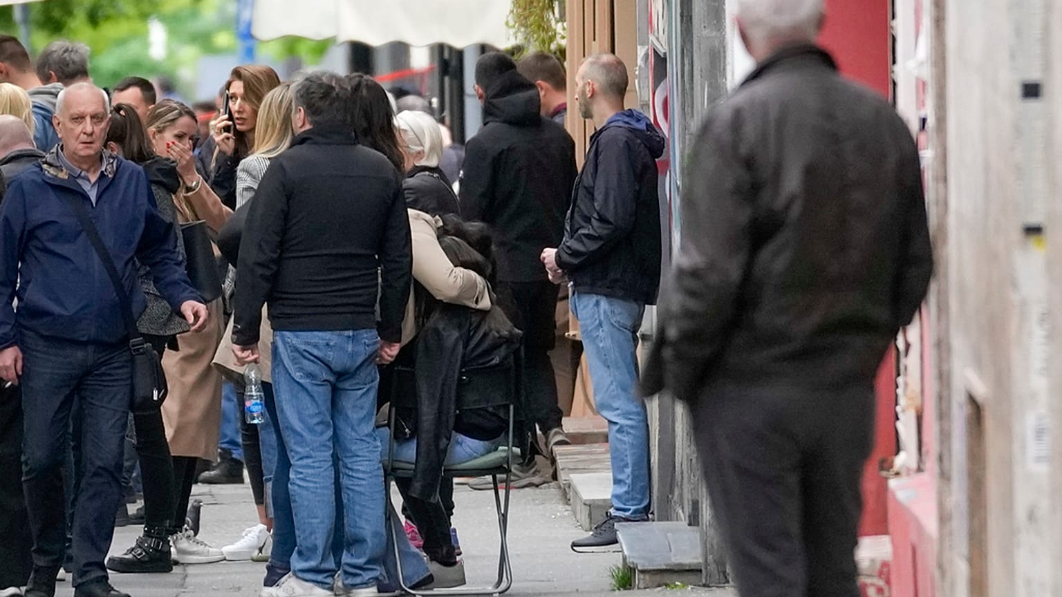 People wait in front of the Vladislav Ribnikar school after shooting in Belgrade, Serbia, Wednesday, May 3, 2023. 