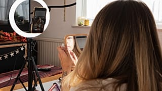 امرأة تضع المكياج وأمامها معدات التصوير 