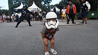 A young fan with a Stormtrooper mask looks on during a festival marking Star Wars Day