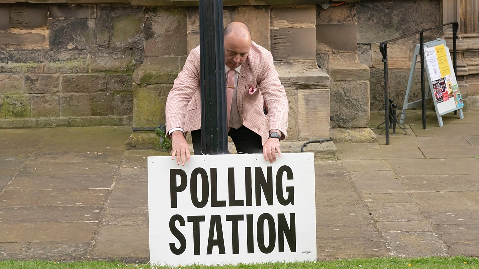 A polling station sign is adjusted outside the polling station in Bridlington, England, Thursday, May 4, 2023. 
