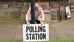 A polling station sign is adjusted outside the polling station in Bridlington, England, Thursday, May 4, 2023. 