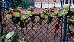 Flores e brinquedos depositados junto à escola Vladislav Ribnikar, em Belgrado, Sérvia