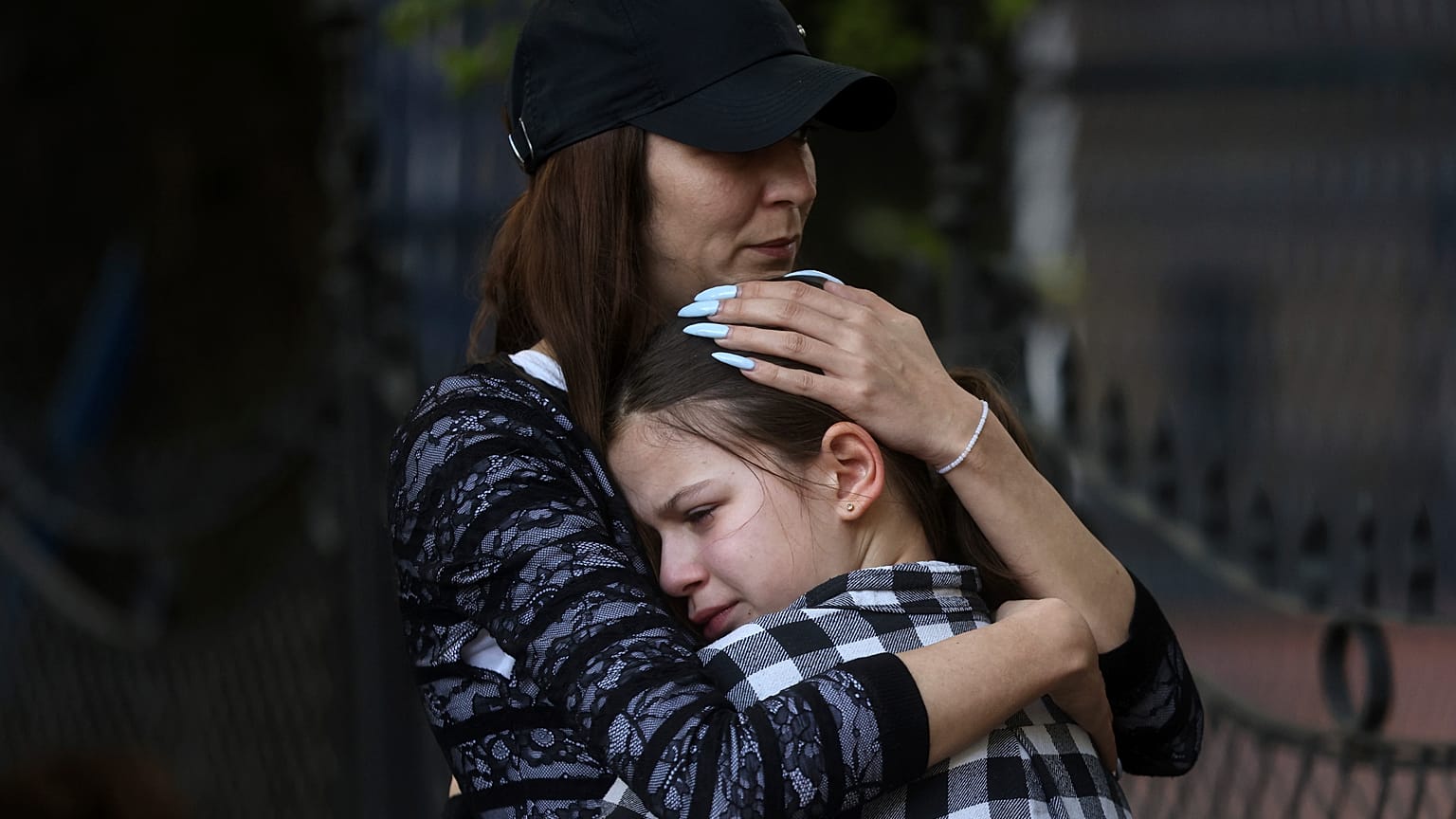 Eine Frau umarmt ein trauerndes Mädchen nach dem Schulamoklauf in Belgrad