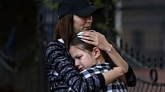 Eine Frau umarmt ein trauerndes Mädchen nach dem Schulamoklauf in Belgrad