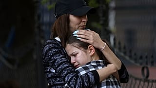 Eine Frau umarmt ein trauerndes Mädchen nach dem Schulamoklauf in Belgrad