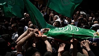 Palestinianos transportam o corpo de Hassan Qatnani, coberto com a bandeira do grupo militante Hamas, durante o seu funeral na cidade de Nablus, na Cisjordânia