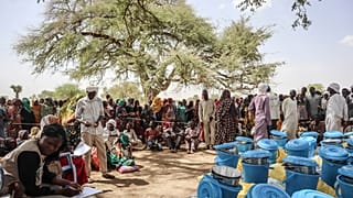 سودانيون يتلقون المساعدات في منطقة تانديلتي بعد عبورهم الحدود إلى تشاد