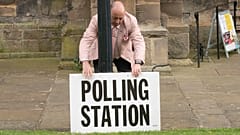 A polling station sign is adjusted outside the polling station in Bridlington, England, Thursday, May 4, 2023.
