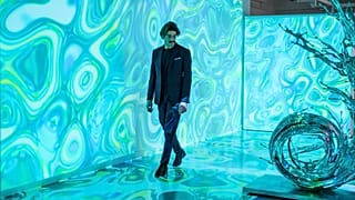 A man walks through the immersive display "Compend AI-XI" by French digital artist Agoria at London's HOFA gallery.