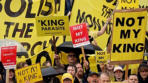 Protesters hold placards as people gather for the coronation of Britain's King Charles III at Westminster Abbey in central London, Saturday, May 6, 2023.