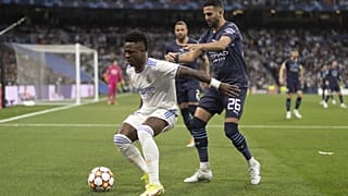 Vinicius Junior (fehérben), a Real Madrid és Riyad Mahrez, a Manchester City játékosa küzd a labdáért a 2022. május 4-i BL-mérkőzésen a madridi Santiago Bernabeu Stadionban.