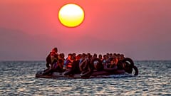 مهاجرون على متن زورق يصلون إلى جزيرة كوس جنوب شرق اليونان بعد عبورهم من تركيا، يوم الخميس 13 أغسطس 2015. 