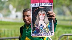 Ein Mann hält ein Plakat mit dem Abbild Rita Lees in die Kamera in Sao Paulo, Brasilien.