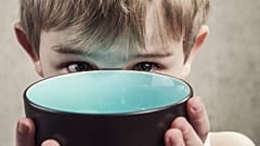 A child with an empty bowl,.