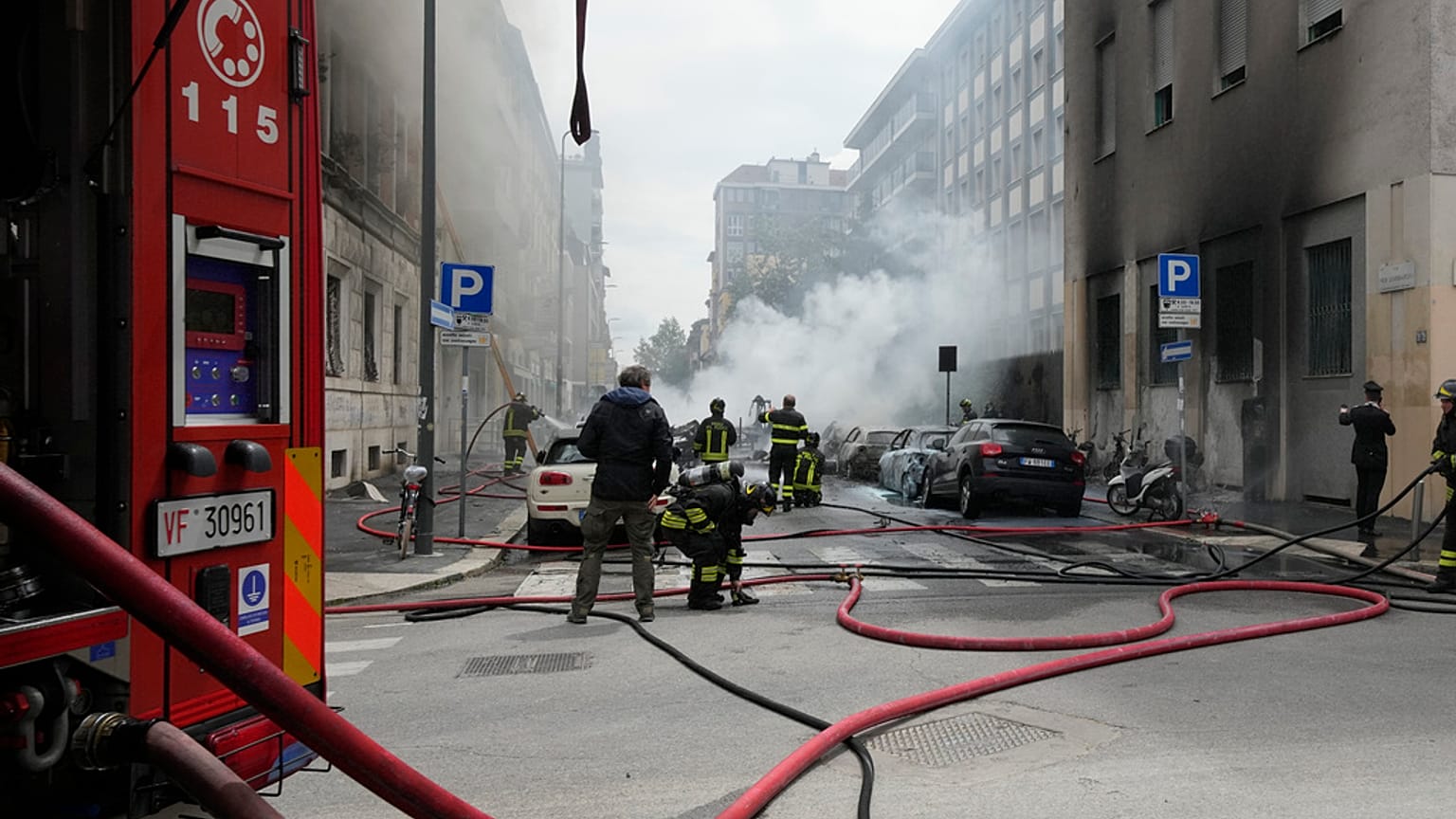 Firefighters work to extinguish a fire in a building after a van exploded in central Milan, northern Italy, Thursday, May 11, 2023. 