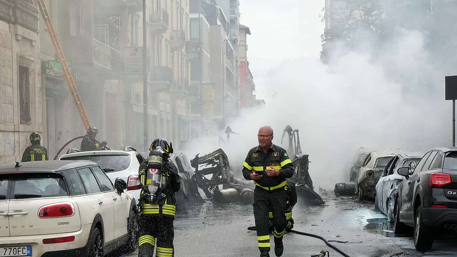 Los bomberos trabajan para extinguir el incendio originado en una furgoneta en MIlán. 