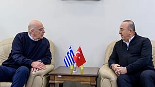 Turkey's Foreign Minister Mevlut Cavusoglu, right, talks with his Greek counterpart Nikos Dendias, in Adana, Turkey, Sunday, Feb. 12, 2023.