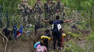Migrantes ante guardias fronterizos en la orilla del río Grande, visto desde Matamoros, México. 11/05/2023
