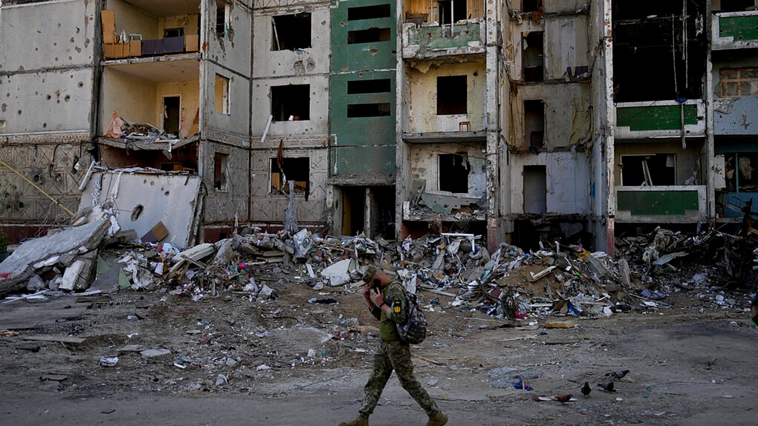 A soldier walks past a building destroyed by attacks in Chernihiv
