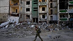 A soldier walks past a building destroyed by attacks in Chernihiv