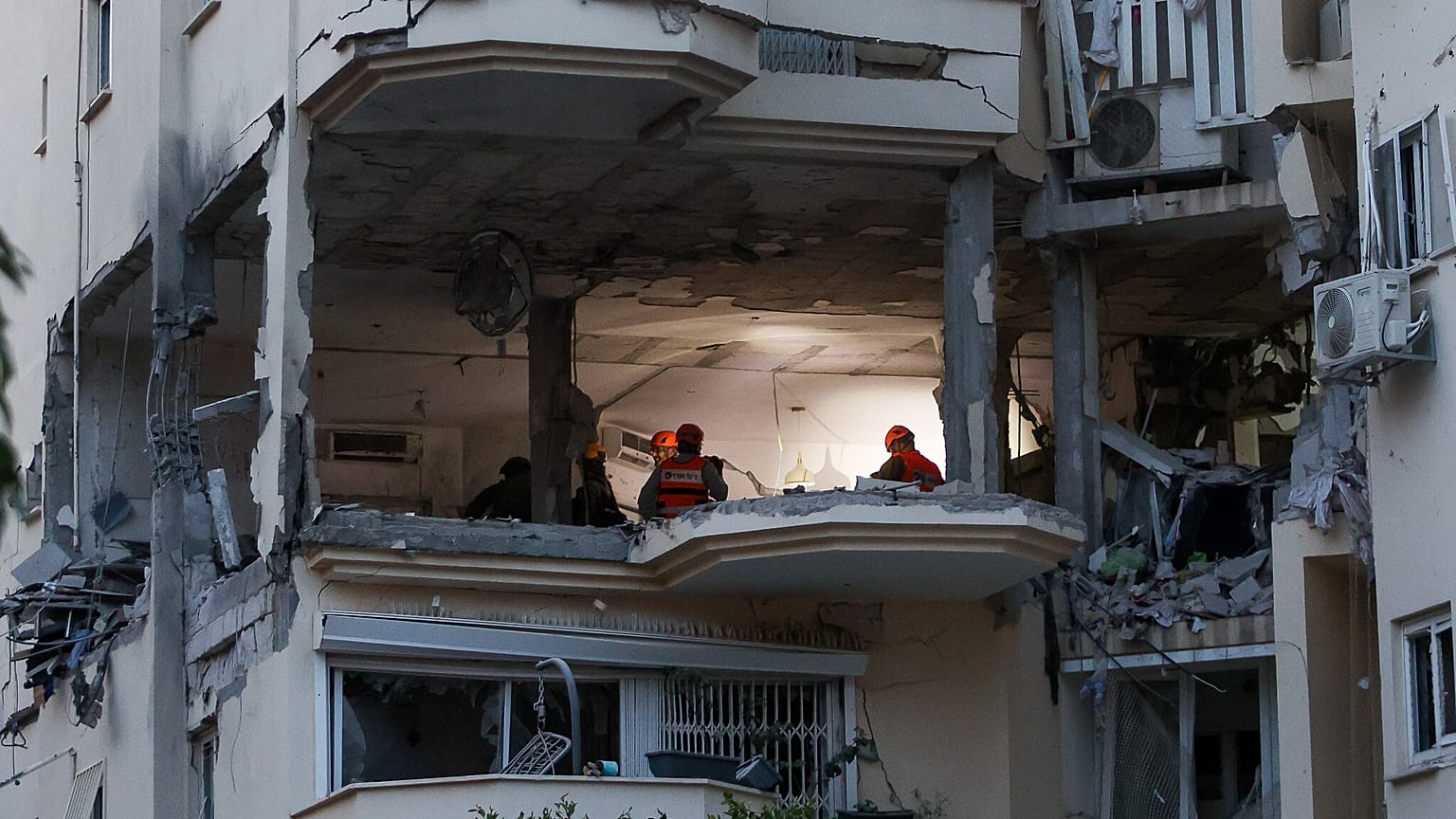 La police et les forces de secours sur les lieux où une roquette tirée de Gaza a touché et endommagé un bâtiment à Rehovot