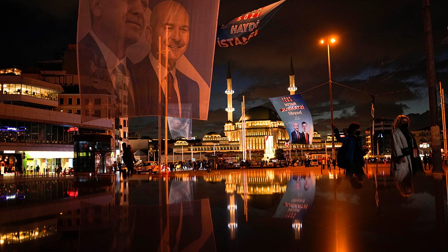 A giant banner of presidential candidates Recep Tayyip Erdogan, left, and Kemal Kilicdaroglu, background right, at Taksim square in Istanbul, Turkey, Wednesday, May 10, 2023. 