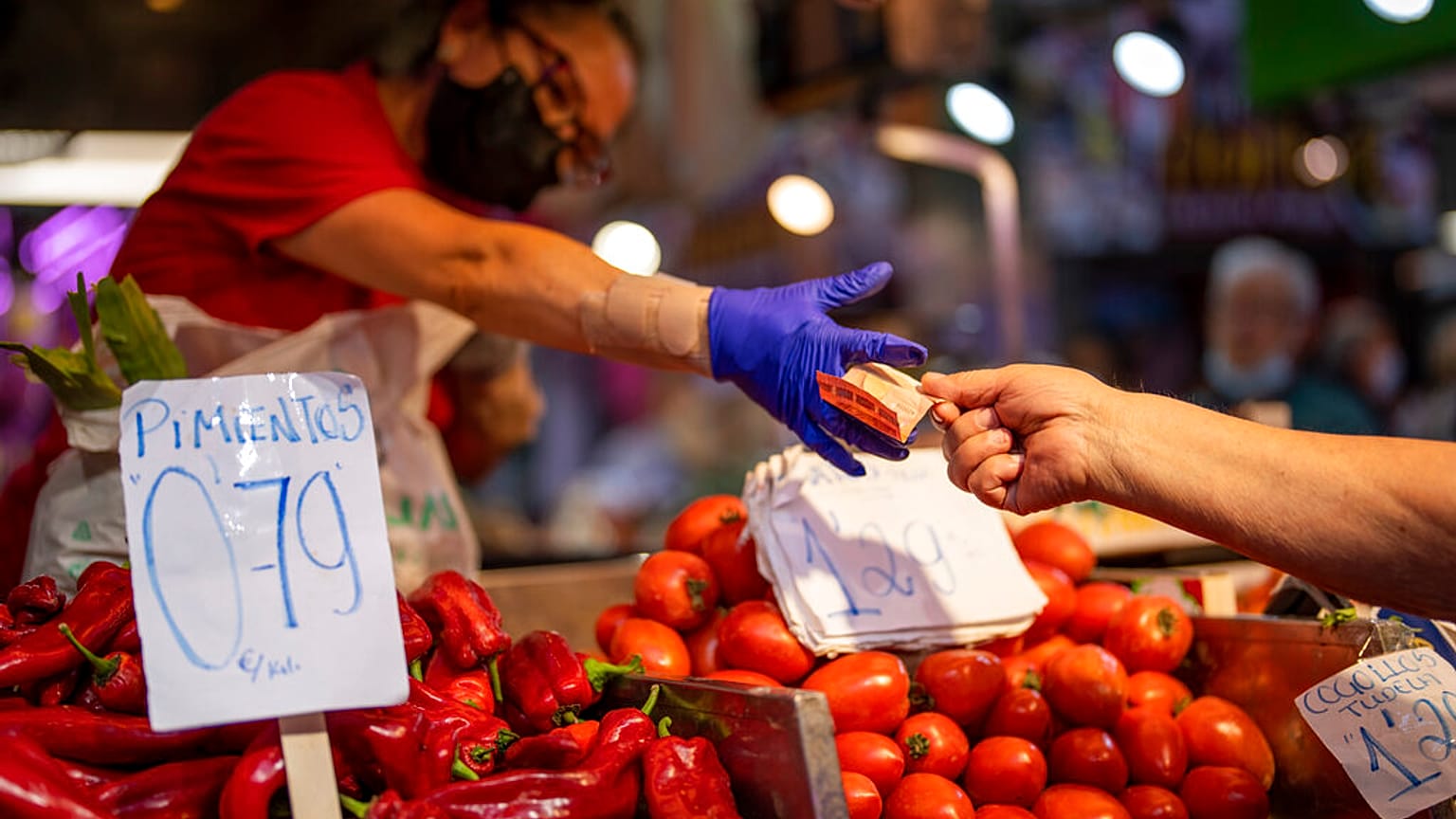 A customer pays for vegetables at the Maravillas market in Madrid, Thursday, May 12, 2022. 