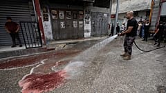 رجل إطفاء فلسطيني يزيل دماء الشابين الفلسطينيين اللذين قتلا برصاص إسرائيلي بمخيم بلاطة