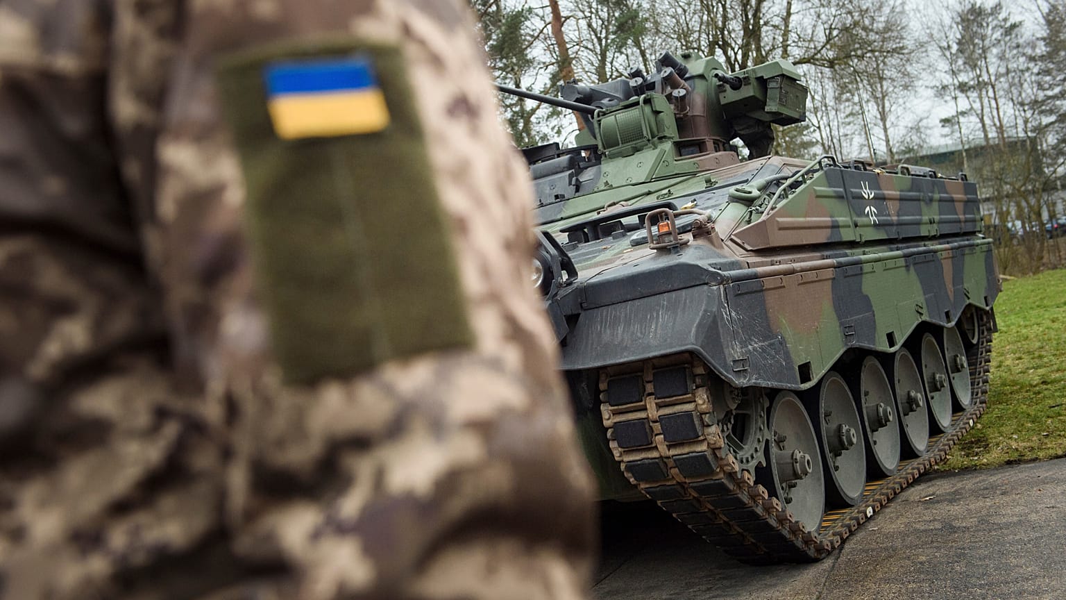 A Ukrainian soldier is standing in front of a Marder infantry fighting vehicle at the German forces Bundeswehr training area in Munster, Germany