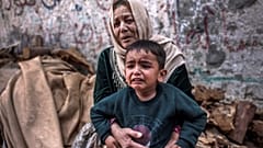 رعب يتملك بطفل فلسطيني ووالدته إثر القصف الإسرائيلي على بيت لاهيا شمال قطاع غزة. 2023/05/13