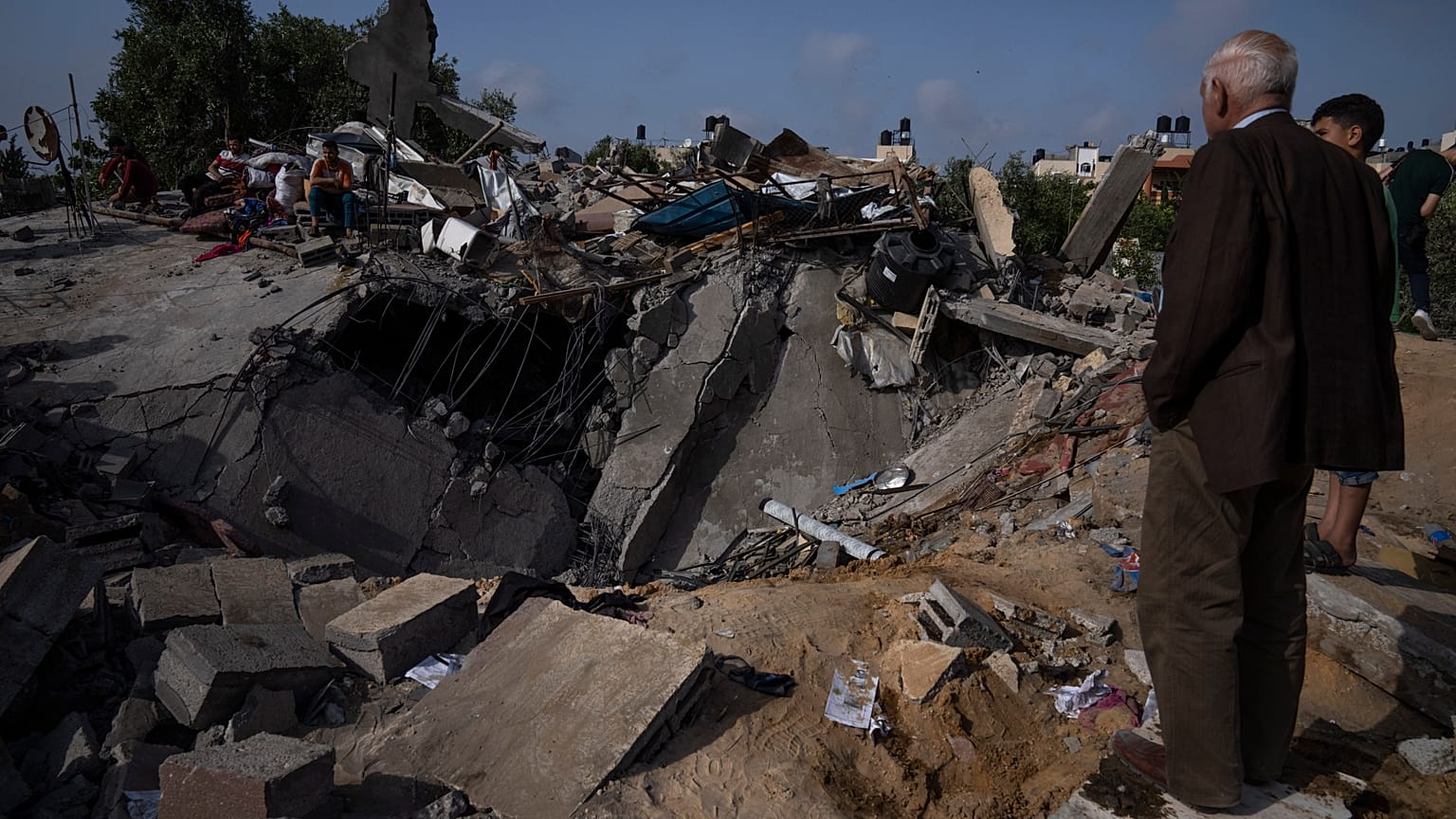 Palesztinok egy ház romjainál egy izraeli légicsapás után Beit Lahiában, a Gázai övezet északi részén, 2023. május 12-én
