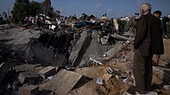 Palesztinok egy ház romjainál egy izraeli légicsapás után Beit Lahiában, a Gázai övezet északi részén, 2023. május 12-én