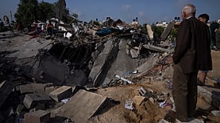 Palesztinok egy ház romjainál egy izraeli légicsapás után Beit Lahiában, a Gázai övezet északi részén, 2023. május 12-én