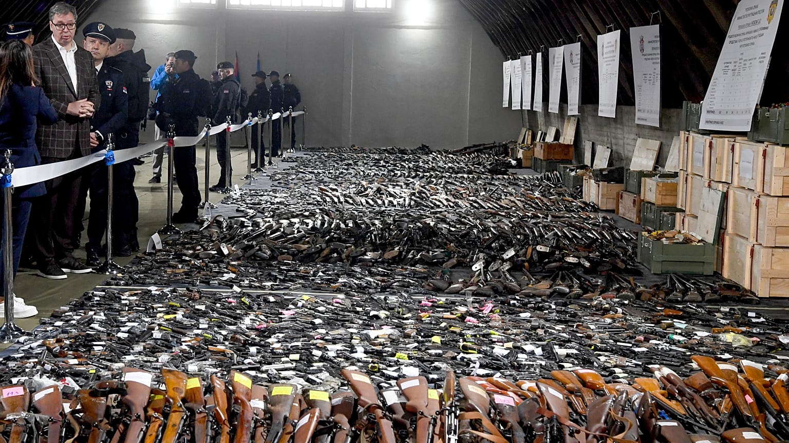 Serbian President Aleksandar Vucic, left, inspects weapons collected near the city of Smederevo
