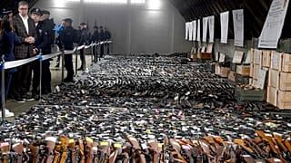 Serbian President Aleksandar Vucic, left, inspects weapons collected near the city of Smederevo