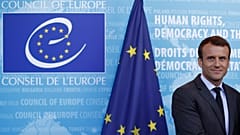 Emmanuel Macron, presidente de Francia ante un logo del CoE