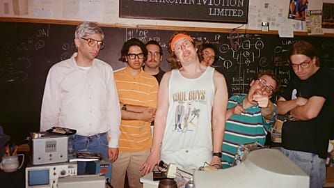 This image released by IFC Films shows Jay Baruchel, left, and actor-director Matt Johnson, center, with cast members on the set of "BlackBerry."