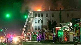 In this image made from video, firetrucks stage outside a hostel in central Wellington, New Zealand, early Tuesday, May 16, 2023